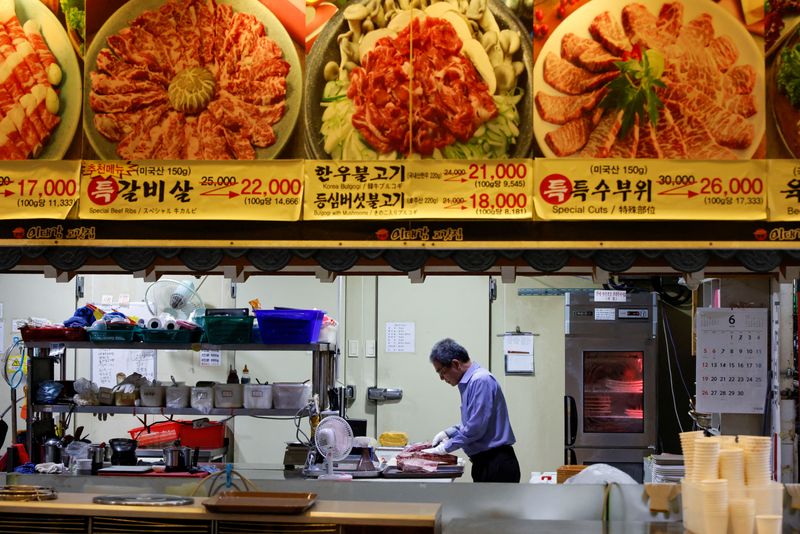 &copy; Reuters. FILE PHOTO: Lee Sang-jae, owner of a meat restaurant, cuts meat at a restaurant in Seoul, South Korea, June 23, 2022. Picture taken June 23, 2022.  REUTERS/ Heo Ran/File photo
