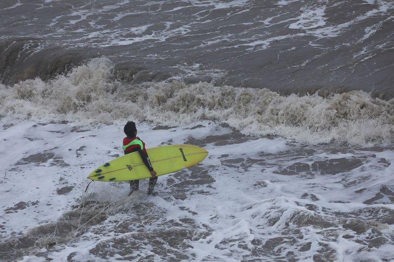 &copy; Reuters. A surfer enters the water at the Mavericks Beach near the Half Moon Bay, California, U.S. December 28, 2023. REUTERS/Nathan Frandino