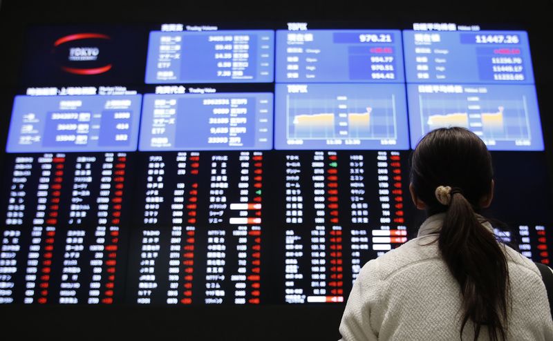 &copy; Reuters. A woman looks at an electronic board showing Japan's stock price index at the Tokyo Stock Exchange in Tokyo February 6, 2013.  REUTERS/Toru Hanai/Files