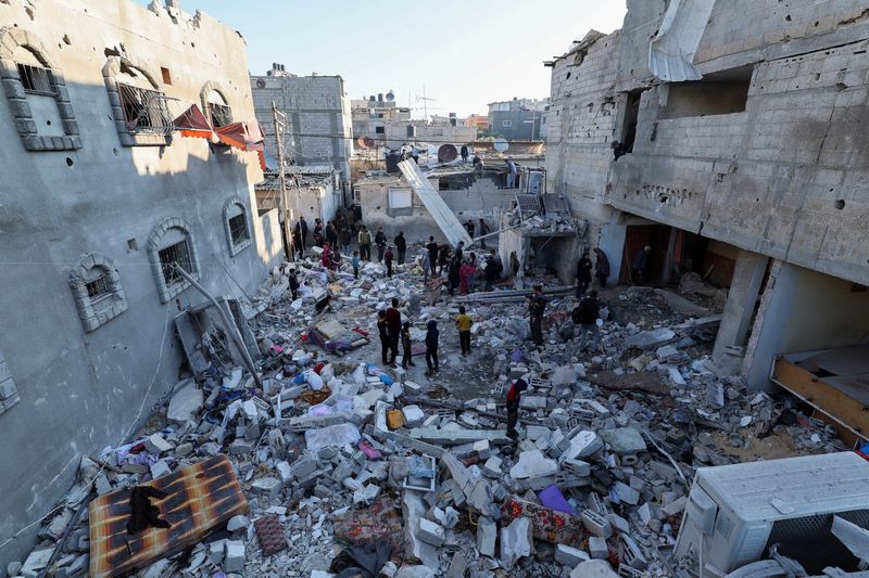 &copy; Reuters. Palestinesi ispezionano il luogo di un attacco israeliano a una casa, nel corso del conflitto in corso tra Israele e Hamas, a Rafah, nel sud della Striscia di Gaza, il 29 dicembre 2023. REUTERS/Ibraheem Abu Mustafa