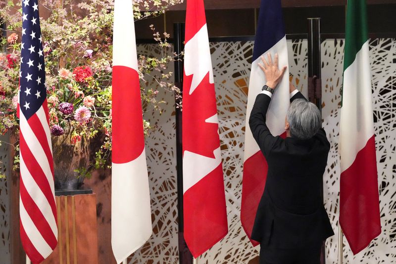 &copy; Reuters. Un membro dello staff sistema le bandiere nazionali prima di una sessione di foto di gruppo durante la riunione dei ministri degli Esteri del G7 presso la Iikura Guest House mercoledì 8 novembre 2023 a Tokyo, Giappone. Eugene Hoshiko/Pool via REUTERS