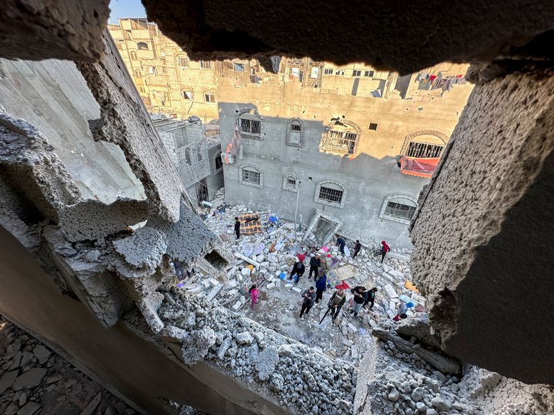 &copy; Reuters. Palestinesi si riuniscono sul luogo di un attacco israeliano a una casa, nel corso del conflitto in corso tra Israele e Hamas, a Rafah, nel sud della Striscia di Gaza, il 29 dicembre 2023. REUTERS/Fadi Shana