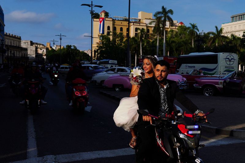 &copy; Reuters. Daniley Aguiar, 21, and Reinier Lopez, 27, ride on an electric motorcycle after their marriage in Havana, Cuba, December 27, 2023. REUTERS/Alexandre Meneghini