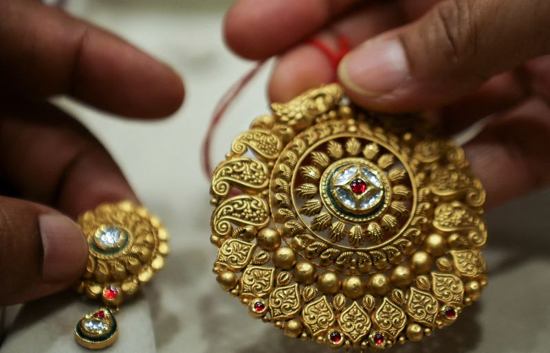 &copy; Reuters. A woman holds a gold ornament at a jewellery shop in the old quarters of Delhi, India, May 24, 2023. REUTERS/Anushree Fadnavis/File Photo