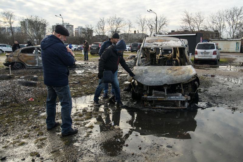 © Reuters. Personas inspeccionan coches destruidos durante un ataque ruso con misiles y drones, en medio del ataque de Rusia a Ucrania, en Kiev, Ucrania 29 de diciembre 2023. REUTERS/Vladyslav Musiienko