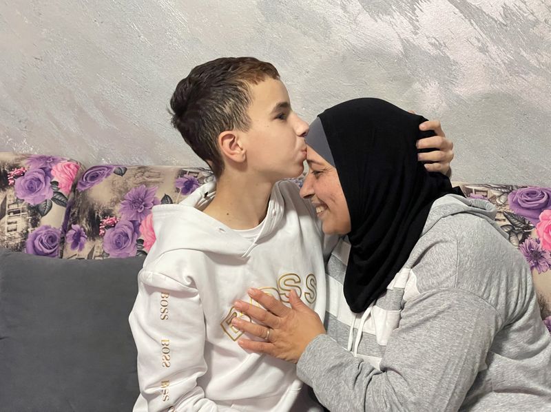 &copy; Reuters. عبد الرحمن الزغل، البالغ من العمر أربعة عشر عاما، يقبل رأس والدته نجاح في منزلهما بالقدس بتاريخ السادس من ديسمبر كانون الأول 2023. تصوير: سنان 