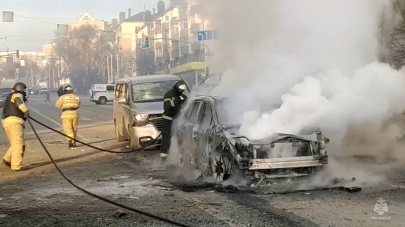 &copy; Reuters. رجال الإطفاء الروس يحاولون إخماد النار التي شبت في إحدى السيارات عقب ما قيل إنه قصف شنته القوات الأوكرانية على مدينة بيلجورود الروسية يوم ا