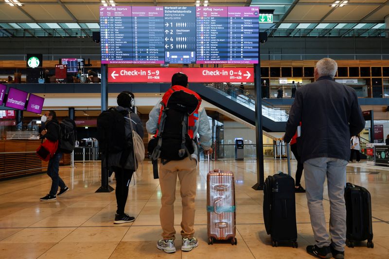 &copy; Reuters. FILE PHOTO: Passengers look at a screen at Berlin Brandenburg Airport (BER), in Schoenefeld near Berlin, Germany, July 7, 2022. REUTERS/Michele Tantussi