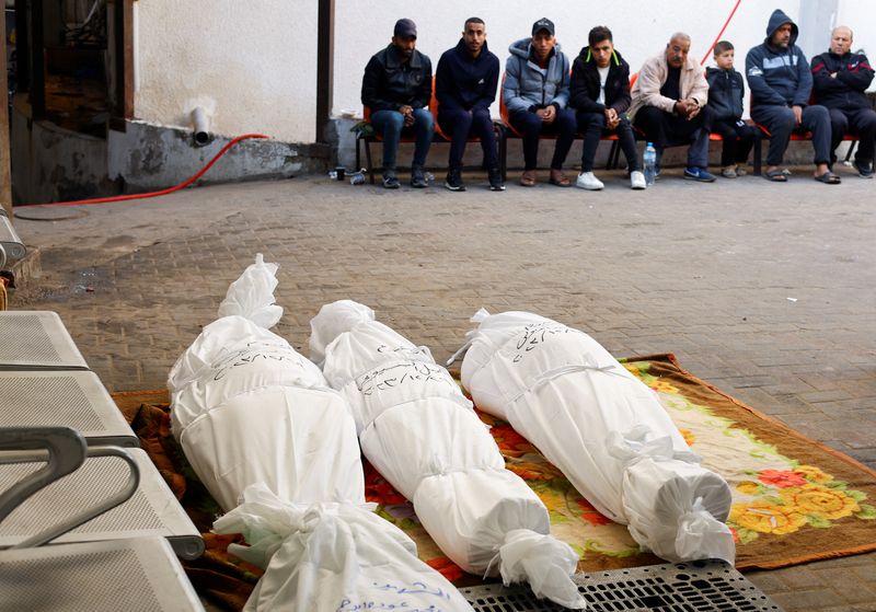 &copy; Reuters. مشيعون يجلوس بالقرب من جثامين فلسطينيين قُتلوا جراء الهجوم الإسرائيلي، وسط الصراع بين إسرائيل وحركة المقاومة الإسلامية حماس، في رفح بجنوب 