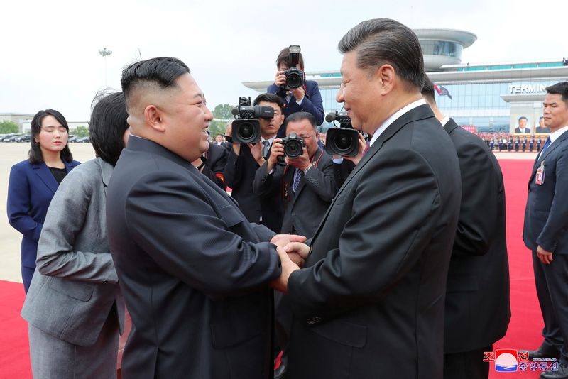 &copy; Reuters. الزعيم الكوري الشمالي كيم جونج أون يصافح الرئيس الصيني شي جين بينغ لدى وصول شي إلى بيونجيانج في صورة أرشيفية لرويترز . 