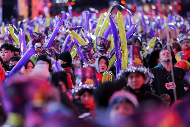 &copy; Reuters. Revellers hold balloons during the New Year's Eve celebrations at Times Square, in New York City, New York, U.S., December 31, 2023. REUTERS/Andrew Kelly