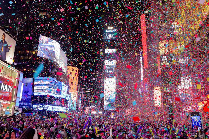 © Reuters. People watch confetti flying around after the clock strikes midnight during New Year celebrations at Times Square, in New York City, New York, U.S., January 1, 2024. REUTERS/Andrew Kelly