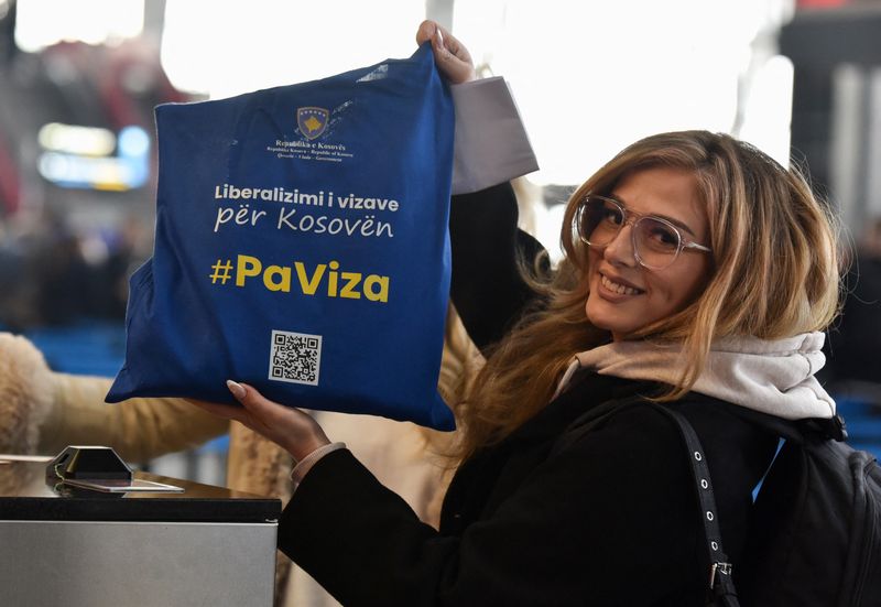 &copy; Reuters. راكبة تحمل حقيبة مكتوب عليها عبارة "بدون تأشيرة" إذ بدأ مواطنو كوسوفو السفر إلى منطقة شنجن دون تأشيرة لأول مرة في مطار بريشتينا يوم الأول من 