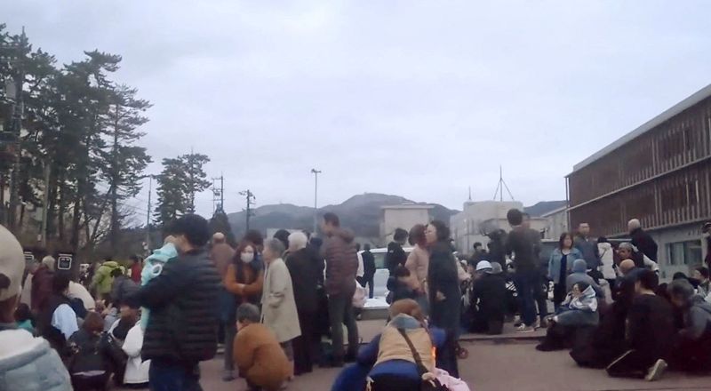 &copy; Reuters. Persone evacuano verso zone più elevate in un parcheggio di una scuola media dopo l'allarme tsunami causato da un terremoto a Wajima, prefettura di Ishikawa, Giappone, 1 gennaio 2024, immagine estrapolata da un video rilasciato da Kyodo. Mandatory credit