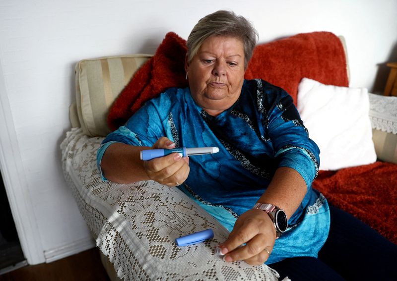 &copy; Reuters. FILE PHOTO: Kim Gradwell begins the Ozempic injection at her home in Dudley, North Tyneside, Britain, October 31, 2023. Gradwell, a retired receptionist with type 2 diabetes, was not able to get her prescription for Ozempic filled in July through the coun