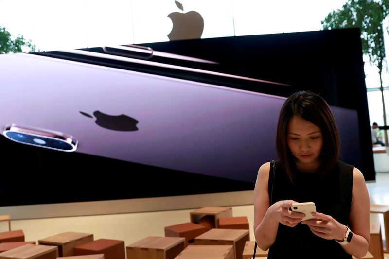 &copy; Reuters. FILE PHOTO: A woman checks her phone at a flagship Apple store at Iconsiam shopping mall in Bangkok, Thailand November 9, 2018. REUTERS/Soe Zeya Tun/File Photo