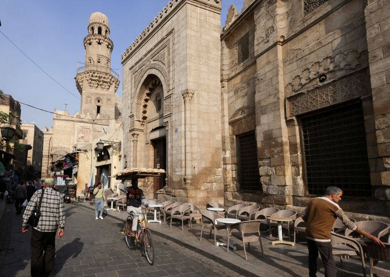 &copy; Reuters. بائع مصري يحمل يبيع الخبز أمام مسجد ومقهى، وسط ارتفاع أسعار المستهلكين، في أحد الأزقة بحي الجمالية في القاهرة القديمة بتاريخ الرابع من ديسم