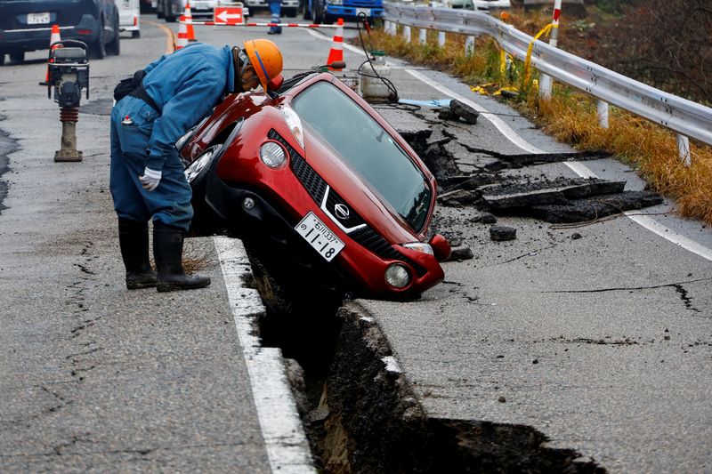 &copy; Reuters. Un trabajador observa un automóvil atascado en una carretera rota tras un terremoto, cerca de Anamizu, Japón. 3 de enero de 2024. REUTERS/Kim Kyung-hoon