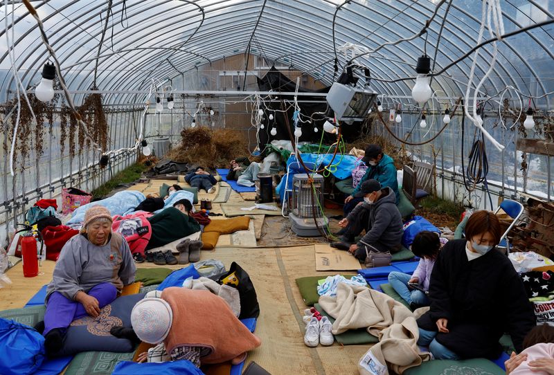 &copy; Reuters. ناجون من الزلزال الذي ضرب اليابان يوم الثلاثاء يجلسون داخل صوبة زراعية تستخدم كمركز للإجلاء في منطقة واجيما بمحافظة إيشيكاوا . تصوير : كيم ك