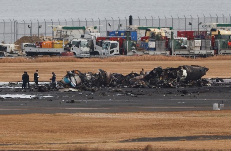 &copy; Reuters. Agentes investigan un avión de la Guardia Costera de Japón incendiado tras una colisión con un avión Airbus A350 de Japan Airlines (JAL) en el Aeropuerto Internacional de Haneda en Tokio, Japón. 3 de enero de 2024. REUTERS/Issei Kato