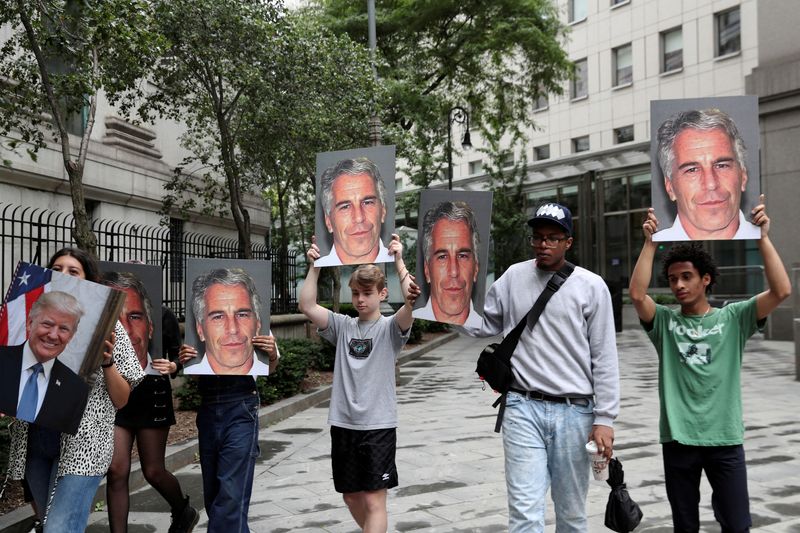 &copy; Reuters. FILE PHOTO: Demonstrators hold signs aloft protesting Jeffrey Epstein, as he awaits arraignment in the Southern District of New York on charges of sex trafficking of minors and conspiracy to commit sex trafficking of minors, in New York, U.S., July 8, 201