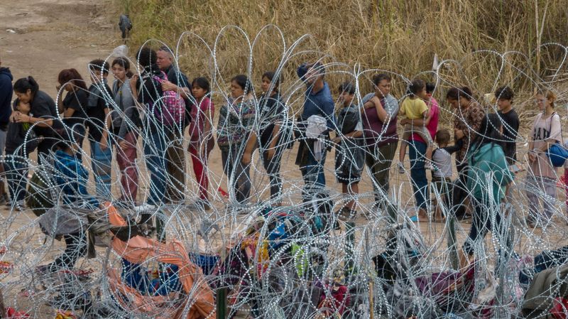 &copy; Reuters. FILE PHOTO: Migrants, most from Venezuela, stand near razor wire while surrendering to authorities after wading across the Rio Grande river into the United States from Mexico, in Eagle Pass, Texas, U.S. October 5, 2023.  REUTERS/Adrees Latif/File Photo