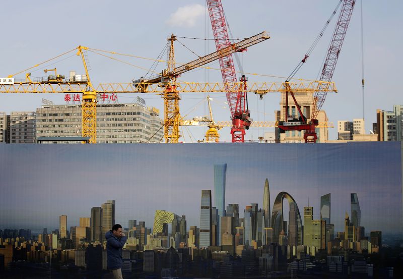 &copy; Reuters. FILE PHOTO: A man walks past the hoarding of a construction site in Beijing December 16, 2014. REUTERS/Kim Kyung-Hoon/File Photo 