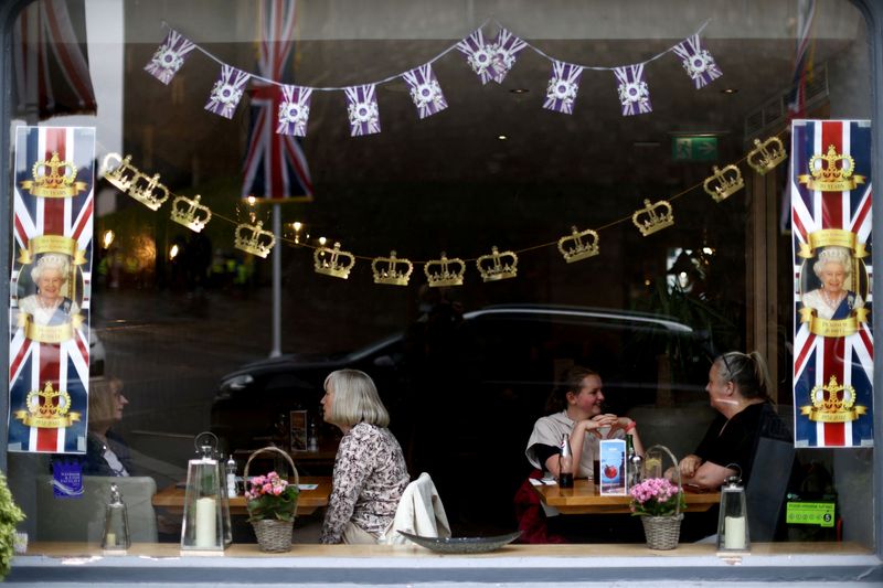 &copy; Reuters. FILE PHOTO: People sit in a restaurant outside Windsor Castle ahead of celebrations for the Platinum Jubilee this weekend in London, Britain, May 31, 2022. REUTERS/Tom Nicholson/File Photo