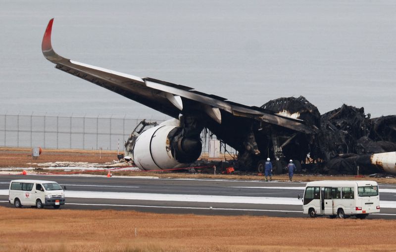 © Reuters. FILE PHOTO: Officials investigate a burnt Japan Airlines (JAL) Airbus A350 plane after a collision with a Japan Coast Guard aircraft at Haneda International Airport in Tokyo, Japan January 3, 2024.  REUTERS/Issei Kato/File Photo