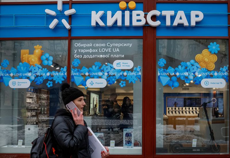 &copy; Reuters. FOTO DE ARCHIVO: Una mujer caminando por delante de una tienda de la compañía ucraniana de telecomunicaciones Kyivstar, en medio del ataque de Rusia a Ucrania, en Kiev, Ucrania. 12 de diciembre 2023. REUTERS/Alina Smutko