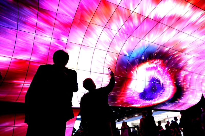 &copy; Reuters. FILE PHOTO: Attendees watch a display on curved OLED screens at the LG Electronics booth during CES 2023, an annual consumer electronics trade show, in Las Vegas, Nevada, U.S. January 6, 2023.  REUTERS/Steve Marcus/File Photo