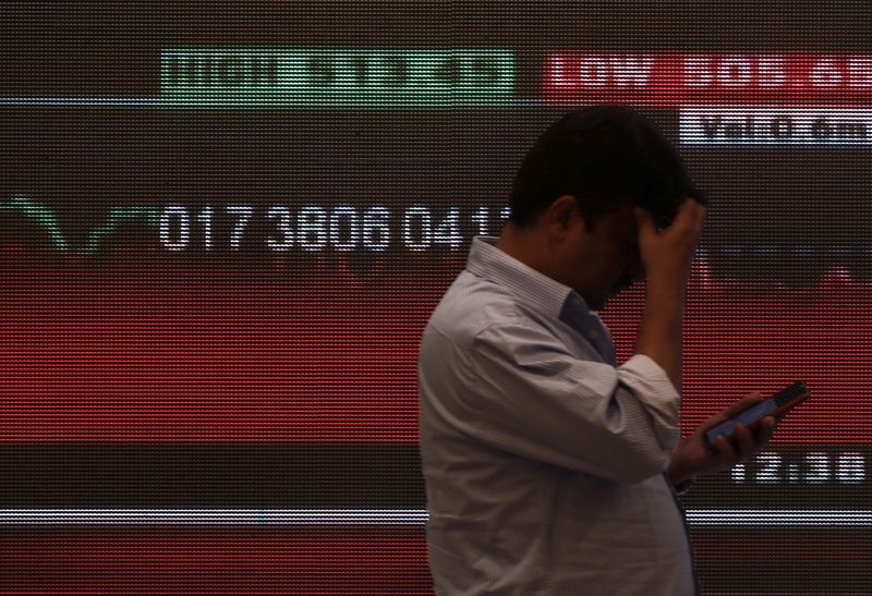 &copy; Reuters. FILE PHOTO: A man stands in front of a screen displaying news of markets update inside the Bombay Stock Exchange (BSE) building in Mumbai, India, January, 3, 2020. REUTERS/Francis Mascarenhas/File Photo