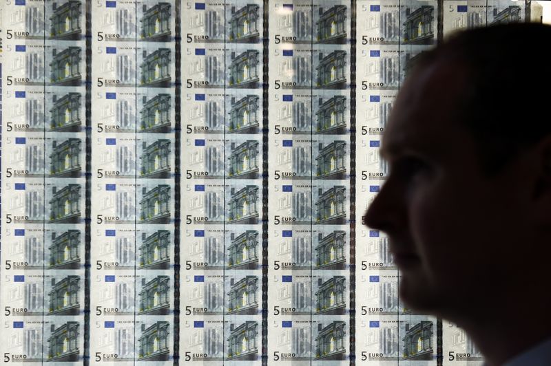 &copy; Reuters. FOTO DE ARCHIVO. Un hombre frente a una hoja de billetes de cinco euros en la inauguración de las nuevas oficinas del Banco Central de Irlanda en Dublín, Irlanda. 24 de abril de 2017. REUTERS/Clodagh Kilcoyne