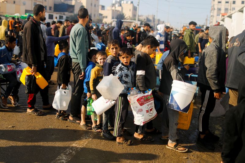 &copy; Reuters. Niños palestinos hacen cola mientras esperan para recoger agua potable, en medio de la escasez de agua potable, mientras continúa el conflicto entre Israel y Hamás, en Rafah, en el sur de la Franja de Gaza el 4 de enero de 2024.  REUTERS/Saleh Salem 