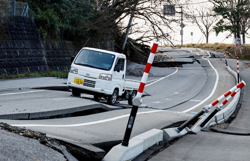 © Reuters. شخص يقود سيارته على طريق مدمر جراء الزلزال في مدينة سوريوماتشي في واجيما بمقاطعة إيشيكاوا في اليابان يوم السبت. تصوير: كيم كيونج هوون - رويترز.