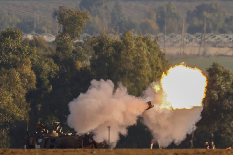 © Reuters. مركبة تابعة لسلاح المدفعية الإسرائيلي تطلق النار قرب الحدود بين إسرائيل وغزة كما شوهدت من جنوب إسرائيل يوم السبت . تصوير : تيرون سيو - رويترز . 