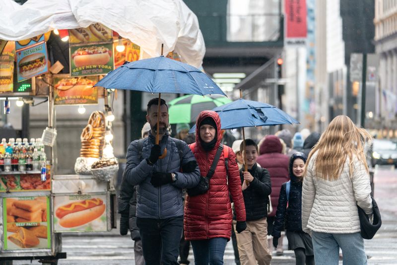 © Reuters. People walk with umbrellas during rainy weather in Manhattan, New York City, U.S., January 7, 2024. REUTERS/Jeenah Moon