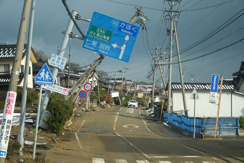 © Reuters. Road signs are tilted over a road damaged by the January 1 earthquake in Nishiaraya, Ishikawa Prefecture, Japan January 8, 2024. REUTERS/Joseph Campbell