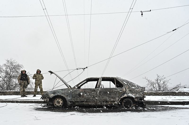 &copy; Reuters. محققان يقفان إلى جانب سيارة دمرت في قصف روسي في منطقة زابوريجيا بأوكرانيا يوم الاثنين في صورة لرويترز.