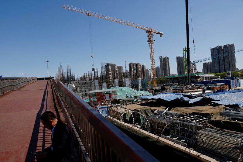 &copy; Reuters. FILE PHOTO: A man sits on an overpass near a construction site of a subway station in Beijing, China April 18, 2023. REUTERS/Tingshu Wang/File Photo