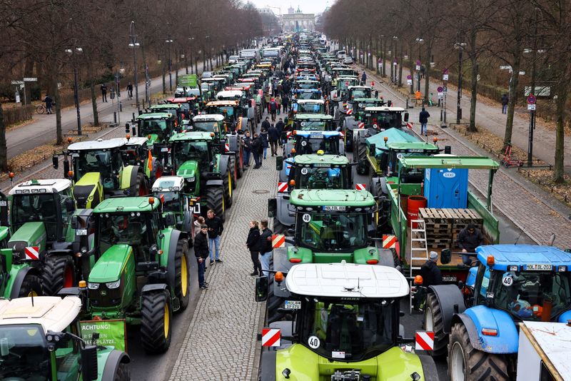 &copy; Reuters. FILE PHOTO: People stand beside tractors, as German farmers take part in a protest against the cut of vehicle tax subsidies, near the Brandenburg Gate in Berlin, Germany, December 18, 2023. REUTERS/Christian Mang/File Photo