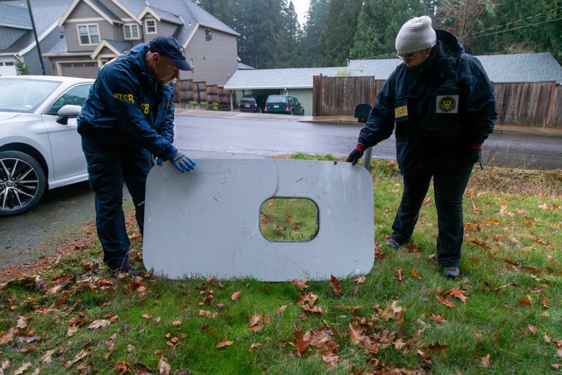 © Reuters. National Transportation Safety Board (NTSB) investigators examine the fuselage plug area of Alaska Airlines Flight 1282 Boeing 737-9 MAX, which was jettisoned and forced the aircraft to make an emergency landing, at a property where it was recovered in Portland, Oregon, U.S. January 8, 2024.  NTSB/Handout via REUTERS