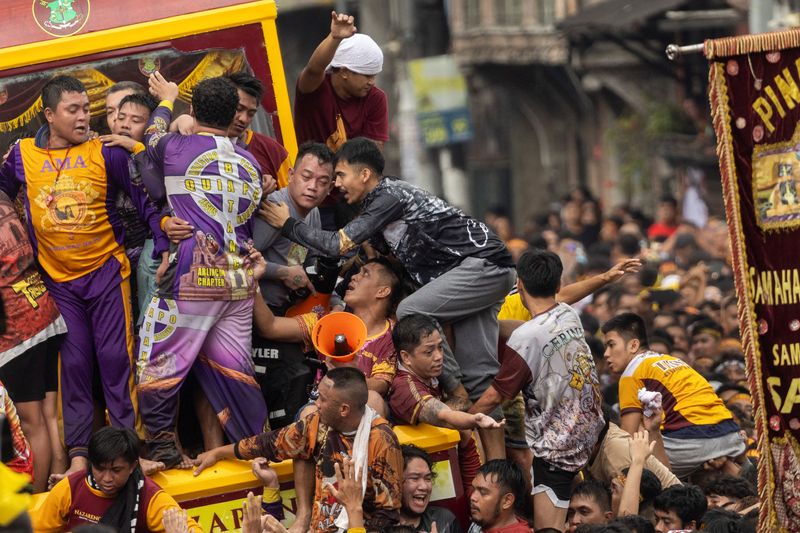 &copy; Reuters. Devotos filipinos se empujan para subir al carro que transporta la estatua del Nazareno Negro durante su procesión anual en Manila, Filipinas. 9 de enero de 2024. REUTERS/Eloisa López