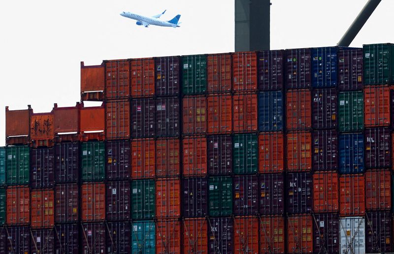 &copy; Reuters. FILE PHOTO: Shipping containers are seen stacked on a docked cargo ship as a passenger airplane takes off from Newark Airport, in Port Elizabeth, New Jersey, U.S., July 12, 2023. REUTERS/Mike Segar/File Photo