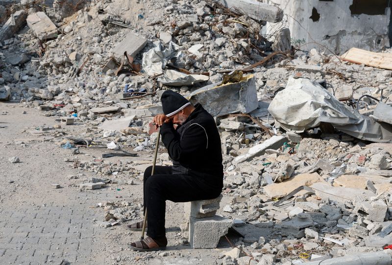 © Reuters. Un palestino sentado cerca de los escombros de una casa destruida en un ataque israelí, en Rafah, en el sur de la Franja de Gaza. 9 de enero de 2024. REUTERS/Mohammed Salem  