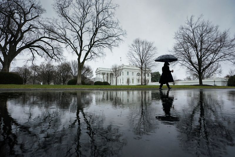 &copy; Reuters. A reporter, arriving for work, walks up the driveway toward the White House on a rain-soaked morning in Washington, U.S., January 9, 2024. REUTERS/Kevin Lamarque      TPX IMAGES OF THE DAY
