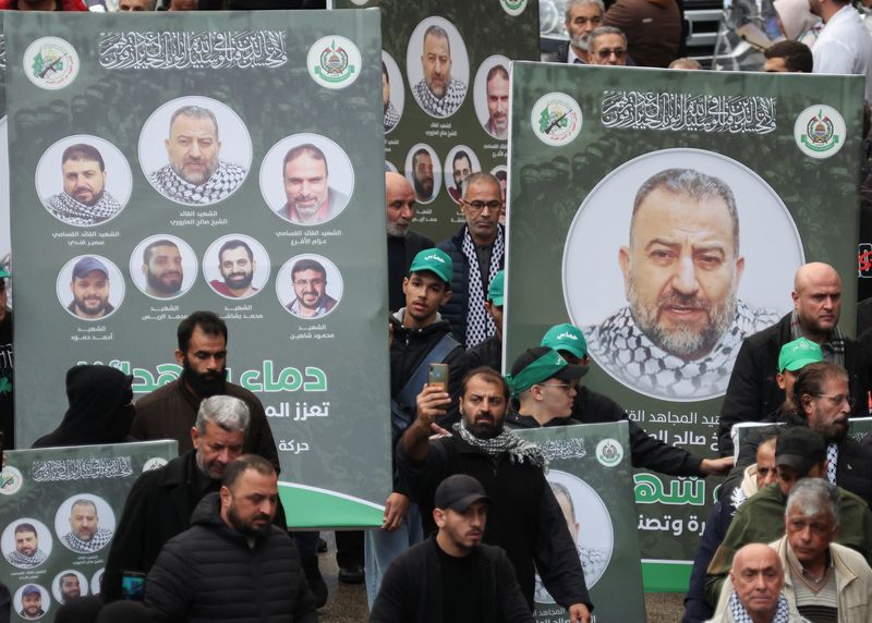 &copy; Reuters. أشخاص يحملون لافتات عليها صور صالح العاروري نائب رئيس المكتب السياسي لحركة المقاومة الإسلامية الفلسطينية (حماس) خلال جنازته ببيروت في الرا