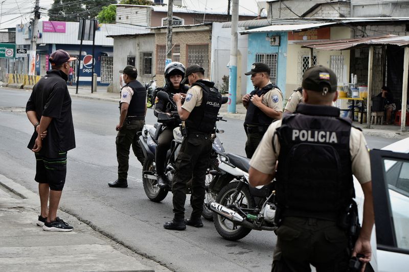 &copy; Reuters. رجال شرطة يتحققون من هوية رجل بعد إعلان حالة الطوارئ في جواياكيل بالإكوادور يوم الثلاثاء. تصوير: فيسنتي جايبور ديل بينو - رويترز.

