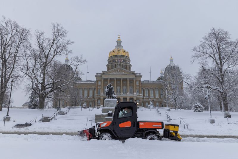 &copy; Reuters. Workers remove snow from the sidewalk outside of the Iowa State Capitol Building after a snowstorm left several inches of snow in Des Moines, Iowa, U.S., January 9, 2024. REUTERS/Alyssa Pointer