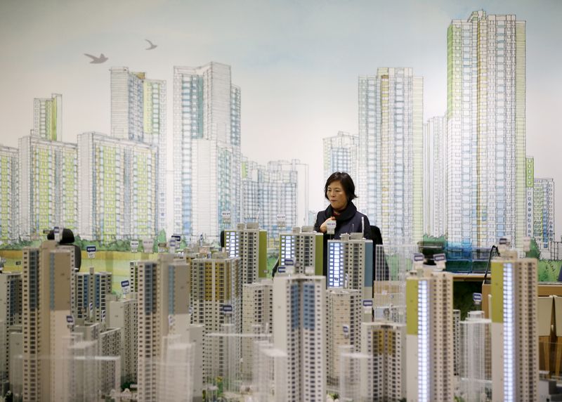 &copy; Reuters. A visitor looks at a miniature model of an apartment complex which is currently under construction at its showroom in Seoul March 18, 2015.  REUTERS/Kim Hong-Ji/File Photo